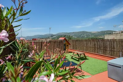a garden with a table and chairs on a patio at Castelldefels - Apartment - Sleeps 4 - Beach Side in Castelldefels