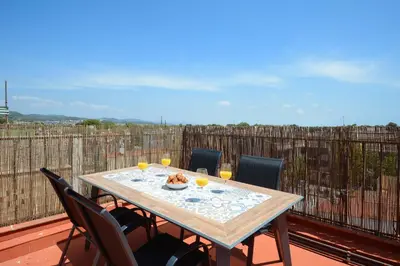 a table on a balcony with chairs and glasses of orange juice at Castelldefels - Apartment - Sleeps 4 - Beach Side in Castelldefels