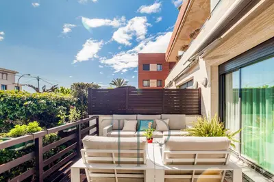 a balcony with a couch and chairs on a building at La Pineda in Castelldefels