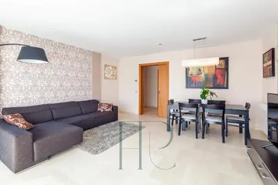 a living room with a couch and a table and chairs at La Pineda in Castelldefels