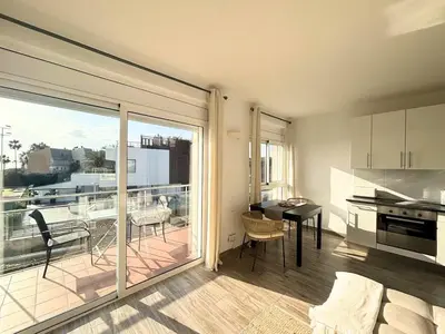 a kitchen and dining room with a view of a balcony at Atico frente al mar! in Gavà