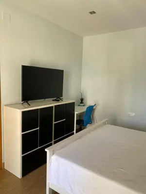 a bedroom with a bed and a flat screen tv at House 50meters from the beach in Cunit