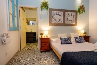 a small bedroom with two beds and a hallway at Estudios a 10' caminando de la playa y a 20' de Barcelona Centro in Sant Adria de Besos