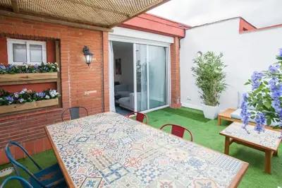 a patio with a table and chairs on the grass at Tendency Apartments 12 Penthouse in Barcelona