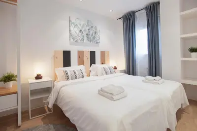 a bedroom with a large white bed with two towels on it at Tendency Apartments 12 Penthouse in Barcelona
