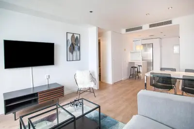 a living room with a couch and a tv on a wall at Tendency Apartments 12 Penthouse in Barcelona