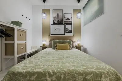 a bedroom with a bed with a green bedspread at Bonito Apartamento en Ronda Sant Pau in Barcelona
