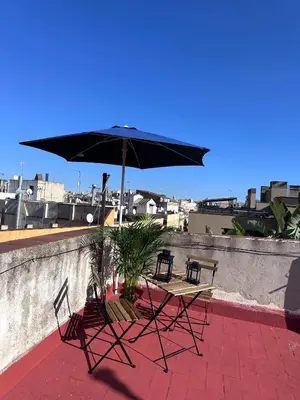two chairs and a table with an umbrella on a patio at Bonito Apartamento en Ronda Sant Pau in Barcelona