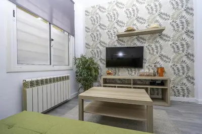 a living room with a tv on a wall at HomeHolidaysRentals Balmes - Costa Barcelona in Calella