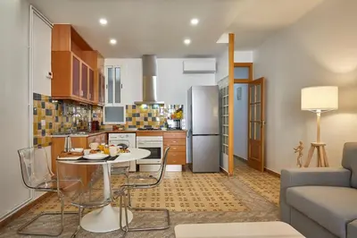 a kitchen and living room with a table and a couch at BBarcelona Perill Flat in Barcelona