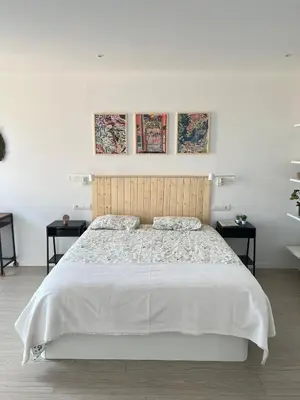 a bedroom with a large white bed with two tables at Artistic beach apartment in Cunit