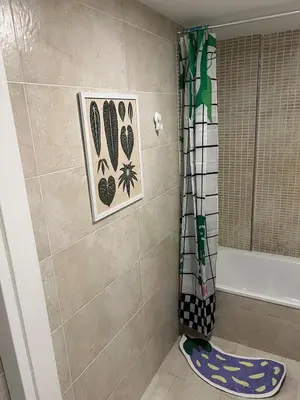 a bathroom with a shower with pictures on the wall at Artistic beach apartment in Cunit