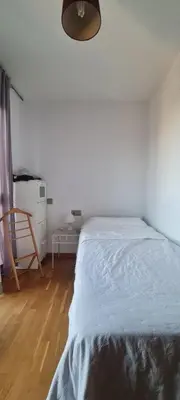 a white bedroom with a bed and a wooden floor at Alojamiento luminoso y bien ubicado en Terrassa Barcelona in Terrassa