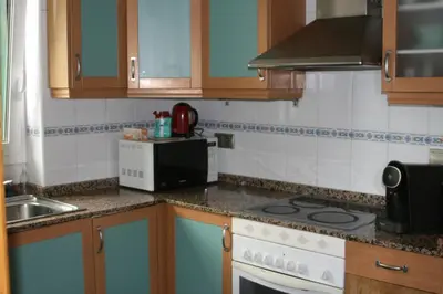 a kitchen with a stove and a microwave at Alojamiento luminoso y bien ubicado en Terrassa Barcelona in Terrassa