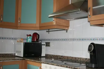 a kitchen with a microwave and a stove top oven at Alojamiento luminoso y bien ubicado en Terrassa Barcelona in Terrassa
