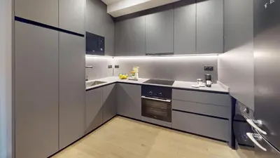 a kitchen with gray cabinets and a stove top oven at Joan Austria 2 Bedroom Apartment in Barcelona