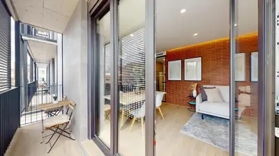 a room with glass walls and a living room at Joan Austria 2 Bedroom Apartment in Barcelona