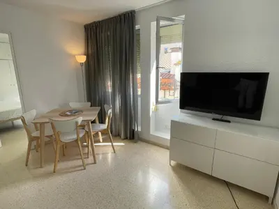 a living room with a dining table and a television at Apartament a Arenys de Mar in Arenys de Mar