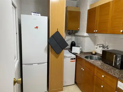 a kitchen with a white refrigerator and a sink at Apartament a Arenys de Mar in Arenys de Mar
