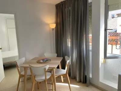 a dining room with a table and chairs and a window at Apartament a Arenys de Mar in Arenys de Mar