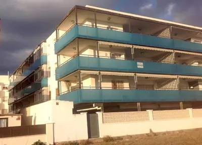 a building with blue balconies on the side of it at Lets Holidays New Flat Beachfront In Castelldefels in Castelldefels