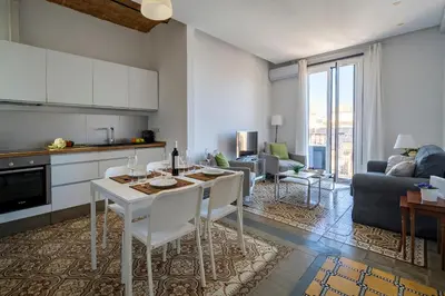 a kitchen and living room with a table and chairs at Habitat Apartments Vila in Barcelona