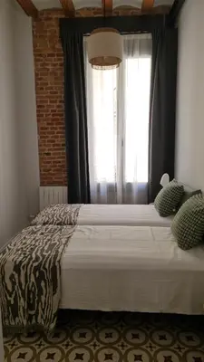 a bedroom with a large bed with a window at Poble Sec Charming Apartment in Barcelona
