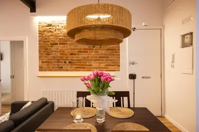 a dining room with a table with a vase of flowers at Poble Sec Charming Apartment in Barcelona