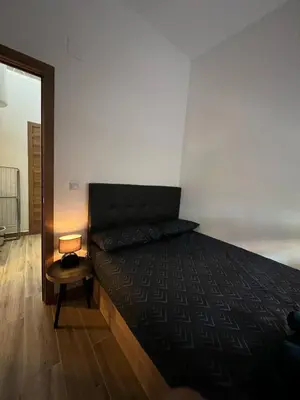 a bedroom with a bed and a table and a mirror at Modern apartment Barcelona in Badalona