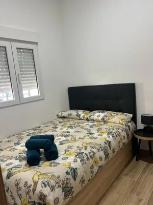a bedroom with a bed with a blue stuffed animal on it at Modern apartment Barcelona in Badalona