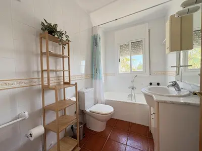 a white bathroom with a toilet and a sink at Charming Catalan Villa with Pool & Views in Cunit