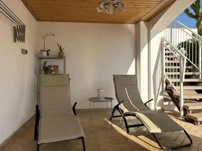 two chairs and a table on a porch at Charming Catalan Villa with Pool & Views in Cunit