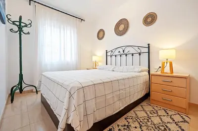 a bedroom with a bed and a dresser and a window at Hauzify I Casa Ribera in Cunit