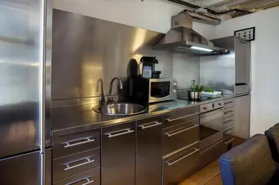 a stainless steel kitchen with a sink and a microwave at Click&Flat Gothic apartments in Barcelona