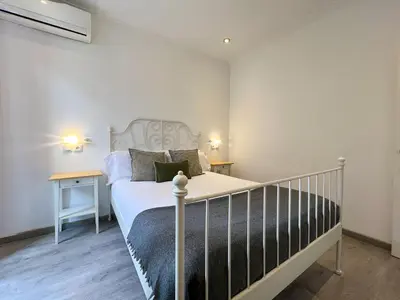 a bedroom with a white bed and two tables at Stay Unique Apartments Mallorca III in Barcelona