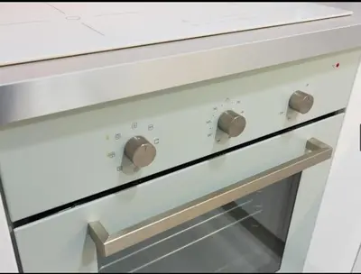 a white stove top oven with two knobs on it at Nice, Cozy, UP TO 6, FCB stadium, free parking in Barcelona