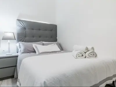 a bedroom with a large white bed with towels on it at Nice, Cozy, UP TO 6, FCB stadium, free parking in Barcelona