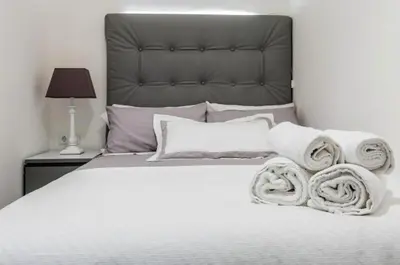 a bedroom with a white bed with towels on it at Nice, Cozy, UP TO 6, FCB stadium, free parking in Barcelona