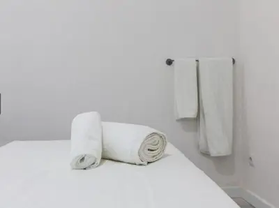 a bed with two rolls of white towels on it at Nice, Cozy, UP TO 6, FCB stadium, free parking in Barcelona