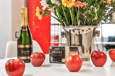 a bottle of champagne and apples on a table at Montroig Mar in Sitges