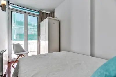 a bedroom with a bed and a chair and a window at Montroig Mar in Sitges