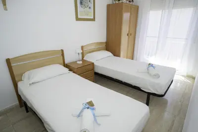two beds in a hotel room with ribbon on them at HomeHolidaysRentals Olai - Costa Barcelona in Pineda de Mar