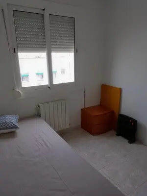 a bedroom with a bed and a dresser and two windows at Dormir sleep Comidad 100 in Barcelona