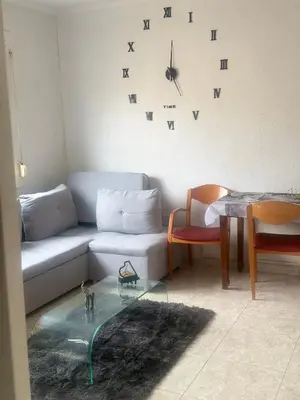 a living room with a couch and a clock on the wall at Dormir sleep Comidad 100 in Barcelona