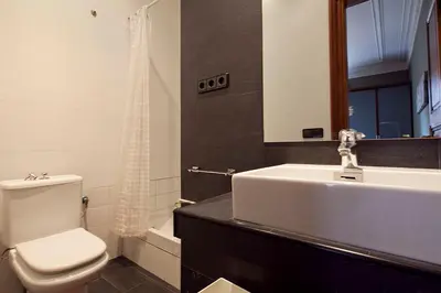 a bathroom with a white sink and a toilet at Catalunya Executive 3 bedrooms, 3 bathrooms AC wifi in Barcelona