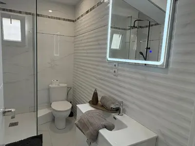 a bathroom with a toilet and a sink and a mirror at FELIPE II Apartment in Barcelona