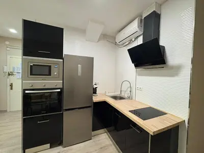 a kitchen with a stainless steel refrigerator and a sink at FELIPE II Apartment in Barcelona