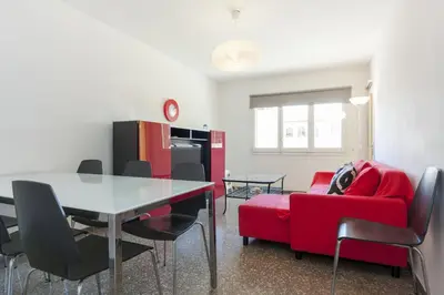 a living room with a table and a red couch at Pubone AT Barberà del Valles in Barbera del Valles