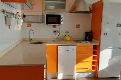 a small kitchen with orange and white appliances at Vistas al mar y garaje cerca de BCN in Sant Vicenç de Montalt