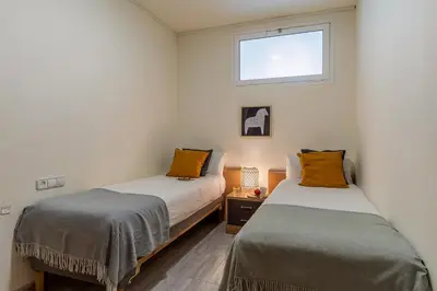 two beds in a small room with a window at Canela Homes BARCELONA ARC DE TRIOMF in Barcelona